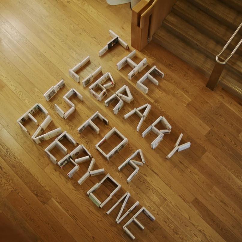 View from above of books on a library floor, spelling the message "the Library is for Everyone"